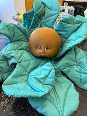 Vintage Kewpie-Style Round Doll Head on Teal Quilted Leaf Mat